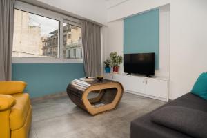 a living room with a tv and a couch at Na'maste Apartments in Athens