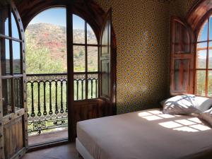 ein Schlafzimmer mit einem Bett und einem großen Fenster in der Unterkunft Alojamiento con Encanto en Málaga in Málaga