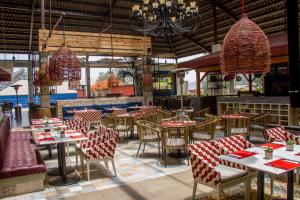 a restaurant with tables and chairs and chandeliers at Decameron El Pueblo in Lima