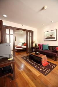 a living room with a couch and a bed at The Siam Heritage Hotel in Bangkok