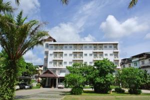 a large white building with trees in front of it at Nana Buri Hotel in Chumphon