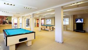 a room with two pool tables and a flat screen tv at Hotel Sol Bariloche in San Carlos de Bariloche
