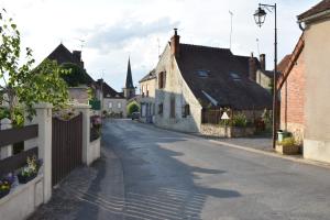 an empty street in a small town with buildings at Place de la Fontaine in Chéniers