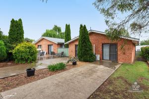 a brick house with a patio and a driveway at Fossicker Caravan Park in Glen Innes