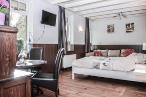 a bedroom with a bed and a table and a chair at Hotel 't Welink in Dinxperlo