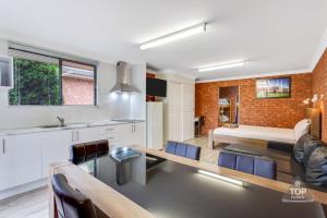 a kitchen and living room with a table and a couch at Fossicker Caravan Park in Glen Innes