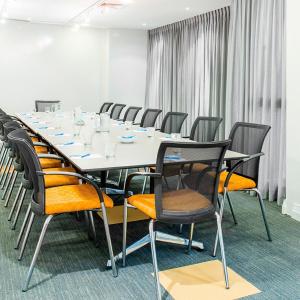 een conferentieruimte met een lange tafel en stoelen bij Mantra on Kent in Sydney