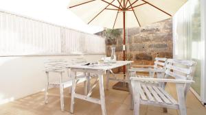 una mesa blanca y sillas con sombrilla en Sa Tanqueta, en Ses Salines