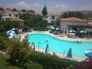 a large swimming pool with umbrellas and people in it at Hylatio Tourist Village in Pissouri