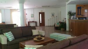 a living room with couches and a coffee table at Hylatio Tourist Village in Pissouri