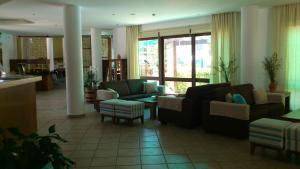 a living room with couches and chairs and a table at Hylatio Tourist Village in Pissouri