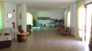a living room with a couch and tables and chairs at Hylatio Tourist Village in Pissouri