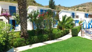 a building with a yard with chairs and trees at Hylatio Tourist Village in Pissouri