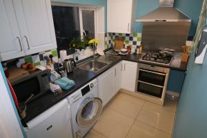 a kitchen with a sink and a washing machine at Riverside Rooms in Reading