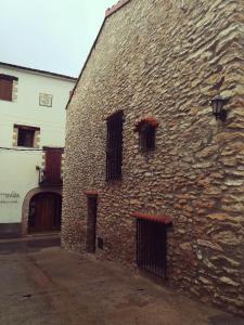 un antiguo edificio de piedra con ventanas y una puerta en Cal cabironet, en Masdenverge