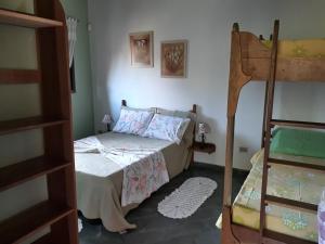 a bedroom with a bed and two bunk beds at Pousada Recanto Águas Vivas com Piscina Aquecida e Lazer Completo próximo a Sorocaba in Turvo dos Góis