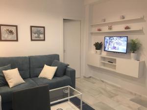 カディスにあるApartamento Calle Nuevaのリビングルーム(青いソファ、テレビ付)