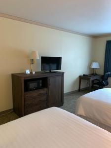 a hotel room with a bed and a flat screen tv at Yellowstone Lodge in West Yellowstone