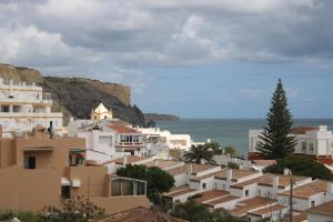 een groep gebouwen op een heuvel naast de oceaan bij Amazing Beach House in Algarve with Sea View! in Luz