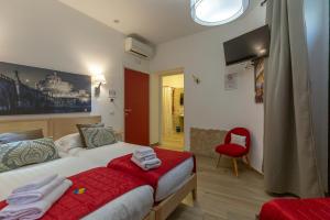 a hotel room with a bed and a red chair at Flatinrome Trastevere Deluxe Rooms - Green Patio in Rome