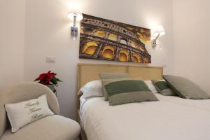 a bedroom with two beds and a chair and a painting at Flatinrome Trastevere Deluxe Rooms - Green Patio in Rome