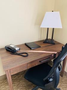 a desk with a telephone and a lamp on it at Yellowstone Lodge in West Yellowstone