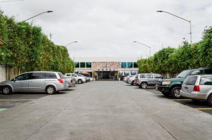 a parking lot with cars parked in front of a building at Hotel Velario in Tijuana