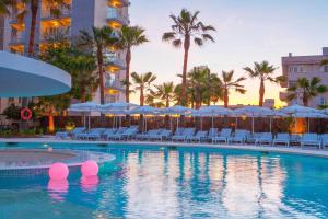 een zwembad met stoelen en parasols in een resort bij JS Palma Stay - Adults Only in Can Pastilla