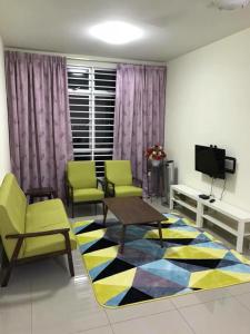 a living room with chairs and a table and a rug at V’Auliya Residence in Putrajaya