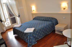 ローマにあるKarina Suiteのベッド、テーブル、窓が備わる客室です。