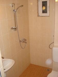 a bathroom with a shower with a sink and a toilet at Kupenova Guest House in Sozopol