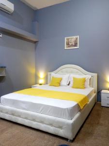 een slaapkamer met een groot wit bed met gele kussens bij Near Rynok Square in Lviv