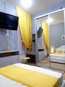 een slaapkamer met een geel bed en een grote spiegel bij Near Rynok Square in Lviv