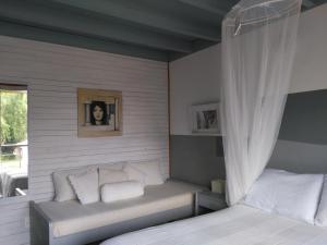 1 dormitorio con cama, sofá y ventana en La Pedrasanta, en La Pedrera