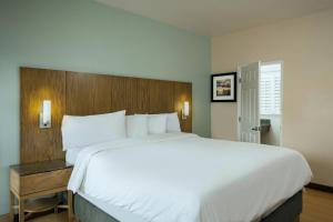 a large white bed in a hotel room at PB Surf Beachside Inn in San Diego +16 photos