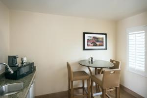 a dining room with a table and chairs in a room at PB Surf Beachside Inn in San Diego