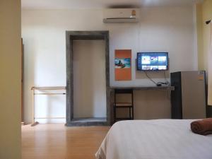 a room with a bed and a tv and a mirror at Prukrom Lanta Guesthouse in Ko Lanta