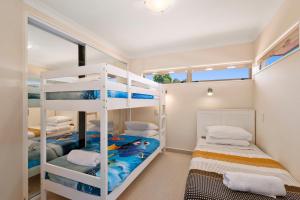a bedroom with two bunk beds and a window at Lake View by Town in Taupo
