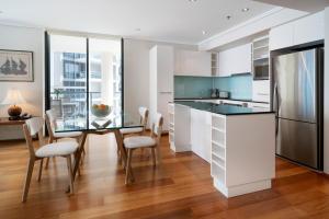 a kitchen with a table, chairs and a refrigerator at Quest River Park Central in Brisbane