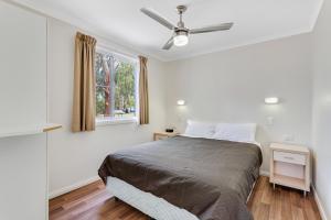 1 dormitorio con 1 cama y ventilador de techo en Narrabri Big Sky Caravan Park, en Narrabri