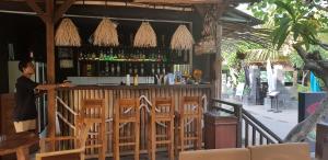 a man standing at a bar in a restaurant at Tiki bar and more in Nusa Lembongan