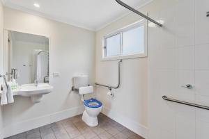 Baño blanco con aseo y lavamanos en Narrabri Big Sky Caravan Park, en Narrabri
