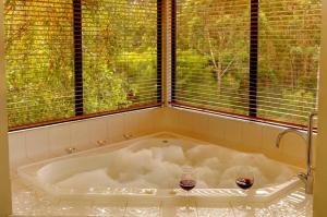 a bath tub with two candles in it in front of a window at Rainbow Trail Chalets in Pemberton