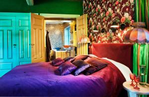 um quarto com uma grande cama roxa com almofadas em Herangtunet Boutique Hotel em Heggenes