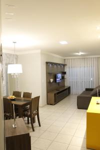 a living room with a dining table and a couch at 3qtos Quadra do Mar Lindo! in Guarapari