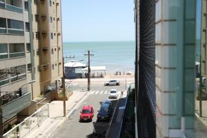 a view of a street with cars parked in a parking lot at 3qtos Quadra do Mar Lindo! in Guarapari