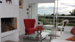 sala de estar con chimenea y silla roja en Edificio Mediterraneo, en Punta del Este