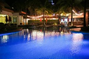 een groot zwembad 's nachts met blauwe verlichting bij The Beach Boutique House in Kata Beach
