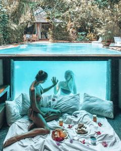 a statue of a couple sitting on a bed in front of a swimming pool at Villa Istimewa in Seminyak