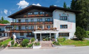 a large white building with flowers in front of it at Hotel Helga in Seefeld in Tirol